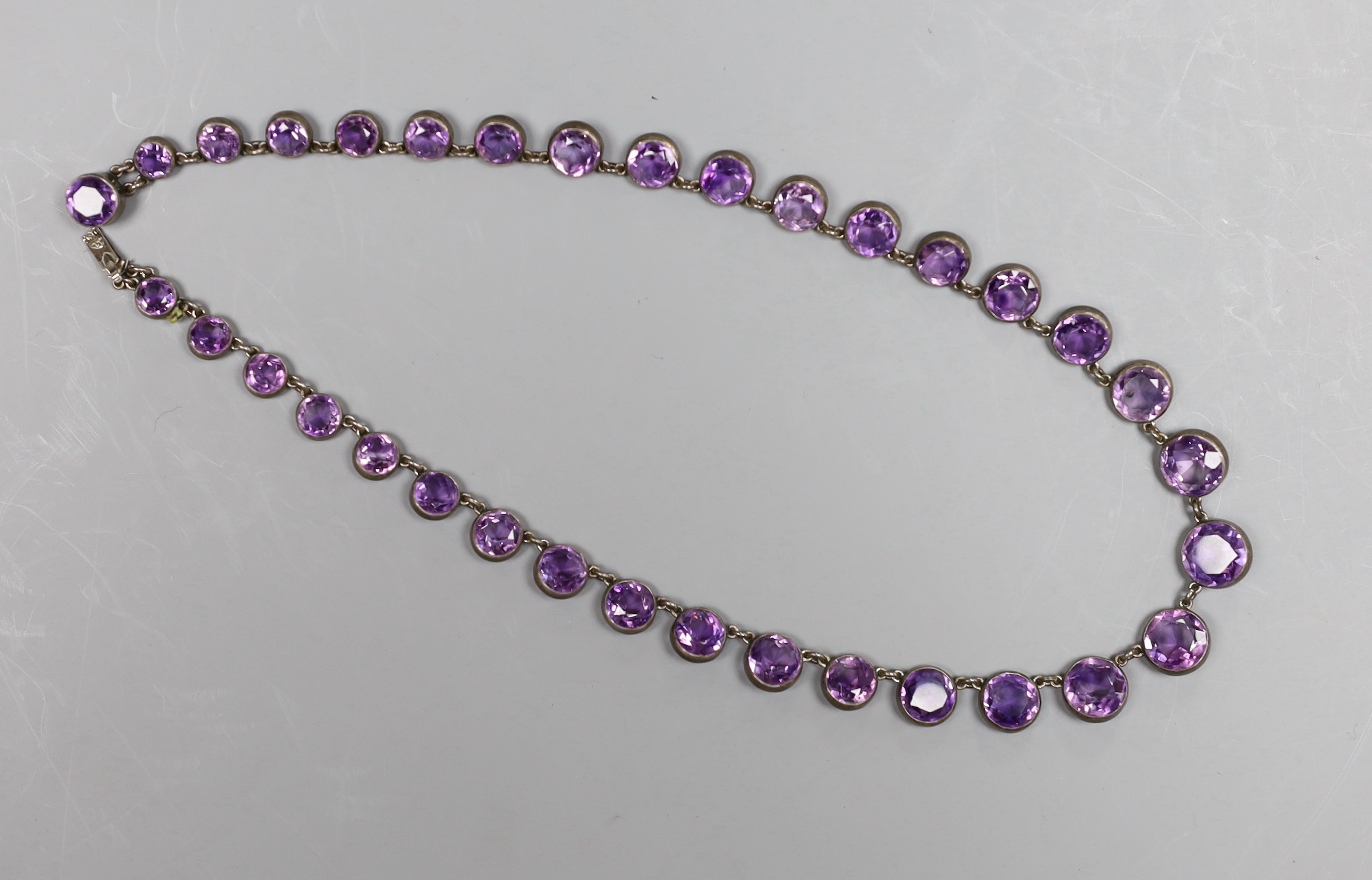 A late Victorian silver mounted circular cut graduated amethyst necklace, 38cm